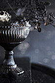 Dark still life with antique silver bowl and dried flowers