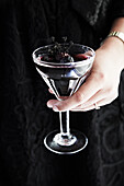 Dark cocktail with berries and thyme