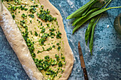Prepare wild garlic bread: roll up the dough with wild garlic pesto