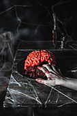 Brain cake for Halloween party with zombie hand
