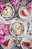 Meringue cake with berries and strawberry cake on a spring table
