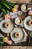 Donuts with caramel icing and coffee with a milk froth heart