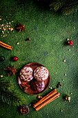 Lebkuchen, Weihnachtsgewürze und Tannenzweige auf grünem Untergrund