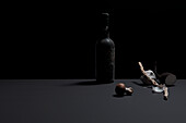 Alte Portweinflasche mit Weinaromen vor schwarzer Hintergrund