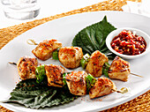 Grilled Yakatori spiced chicken skewers on Perilla leaves with sweet chili dipping sauce