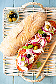 Ciabatta sandwich with tomatoes, olives and mozzarella for a picnic