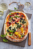 Schnell zubereitete Pizza mit Schinken, Champignons und Gemüse
