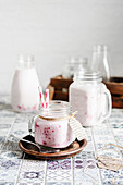 Raspberry milkshake in jar with straws