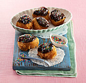 Brandteig-Donuts mit Schokoladenglasur und bunten Zuckerstreuseln