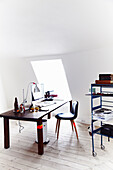 Simple study with wooden table, chair and shelf, sloping ceiling