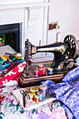 Vintage sewing machine with floral fabric and cotton reels for crafting