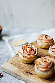 Apple rose muffins on a wooden board