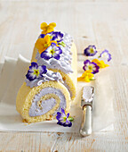 Biskuitroulade mit Lavendelcreme dekoriert mit Essblüten