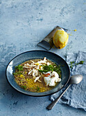 Herb soup with quinoa, chicken and a poached egg