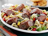 Classic Italian dinner of sweet sausage, tri color bell peppers and Campanelle pasta with herbs and shredded Parmesan