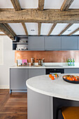 Küchenzeile mit hellgrauen Schrankfronten und ovale Kücheninsel