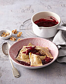 Ravioli with nut filling and sour cherry sauce