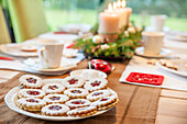 Spitzbuben auf weihnachtlich gedecktem Tisch