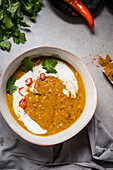 Pumpkin dahl with a swirl of coconut cream, topped with Chopped chilli and corriander