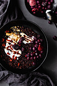 Black rice pudding with coconut yogurt, frozen berries and goji berries