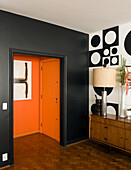 Flat in 60s style, with black wall and orange entry way