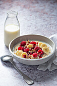 Winter porridge with raspberries, bananas and pomegranate seeds