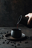 Pouring mulled wine into black mug