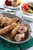 Pork ham rolls stuffed with bacon, pickled cucumber and paprika