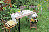 Garden table with birch bark decorations, two chairs and wooden box