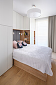 Double bed in bright bedroom with built-in wardrobes