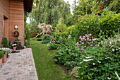 Paved path with planters in front of wooden house