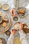 Hands with coffee cups and apple almond cake