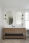 Twin washbasins below mirrors in bathroom