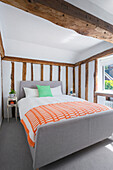 Double bed in bedroom with rustic wooden beams