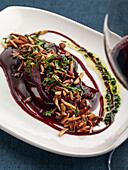 Braised beef tongue in a red wine sauce with almonds and raisins