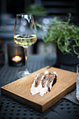 Anchovis mit Lardo auf Brot dazu ein Glas Weißwein