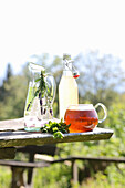 Herbal tea, lavender water, and lemonade on a table outside