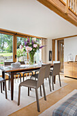Dining area with leather chairs in front of patio door in a converted barn