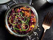 Asian red cabbage salad with sesame seeds in a jar