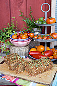 Stand with various tomatoes and tomato box bread with pumpkin seeds