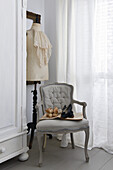 Ruffled jabot on a dressmaker's dummy and baroque upholstered chair