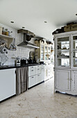 Large shabby-chic kitchen with glass-fronted cabinet as room divider