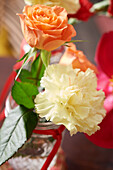 Salmon-coloured rose and white carnation as table decoration