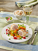 Fish roulades with ham on sliced vegetables