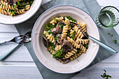 Vegan pasta and mushroom pan with rocket, pine nuts and almond cheese