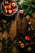 Christmas decoration with apples, fir branches and straw stars on a wooden background