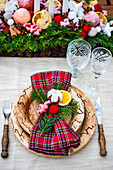 Holz-Gedeck mit karierter Stoffserviette fürs festliche Weihnachtsessen