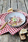 Bavarian sausage salad with radishes and pickled cucumber