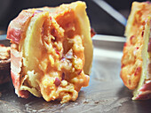 Stuffed baked potato wrapped with bacon and cheese