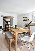 Weiße Küche mit Esstisch und Bank aus hellem Holz und Klassiker Stühle